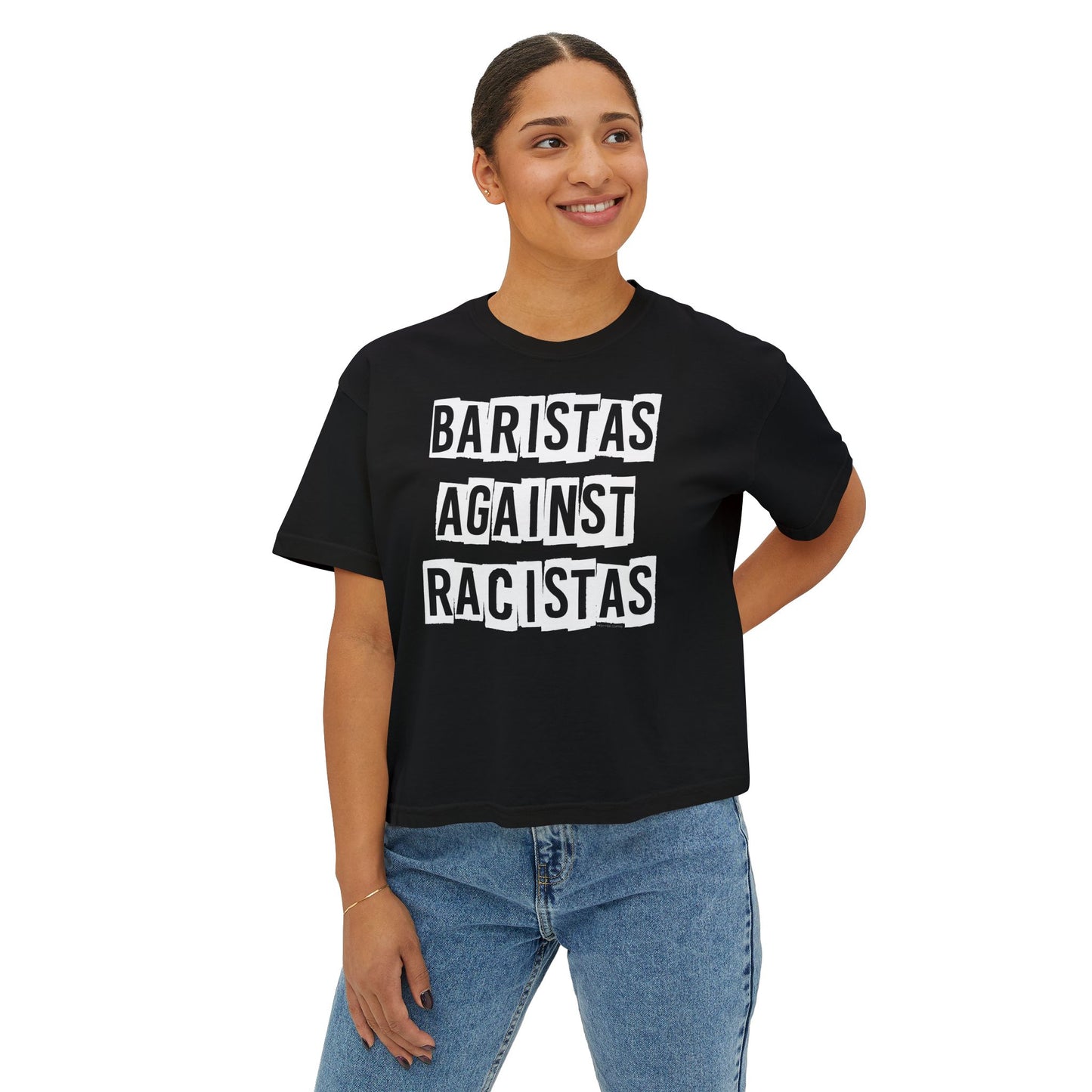 A young lady standing, wearing a black tee shirt that says Baristas Against Racistas