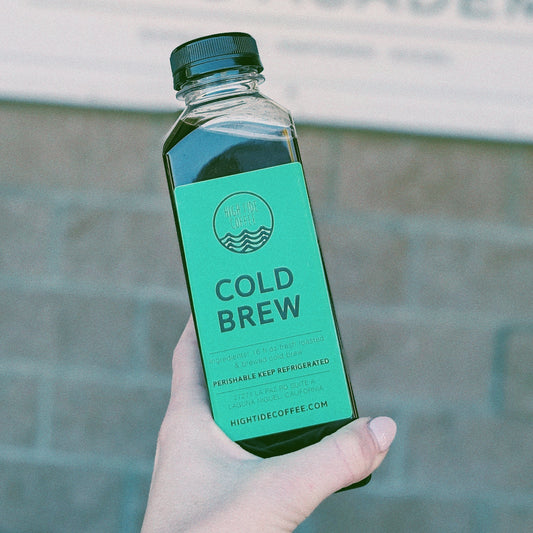 hand holding a bottle of fresh made cold brew coffee