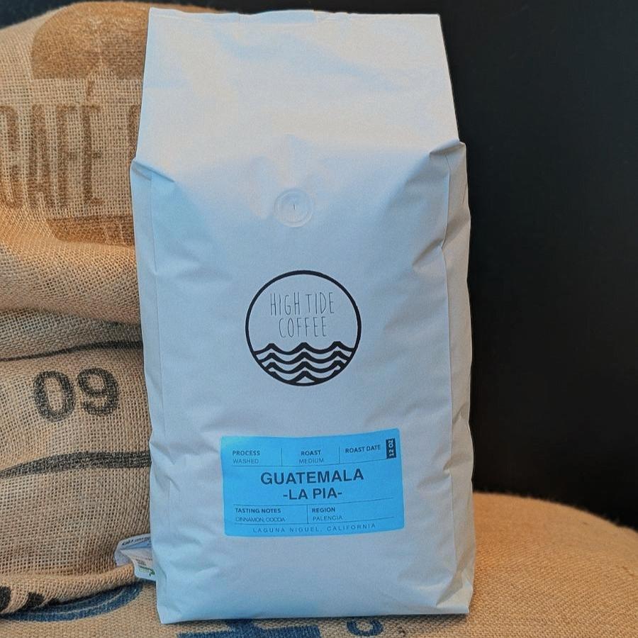 five pound bag of coffee beans sitting on a pile of burlap bags