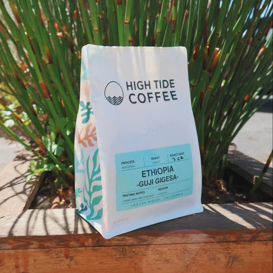 High Tide Coffee bag with Ethiopia Guji Gigesa on a wooden surface with plants in the background