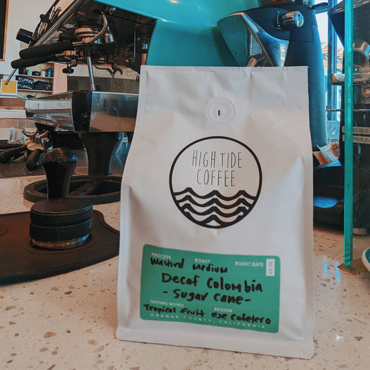 bag of decaf coffee from colombia sitting next to an espresso machine